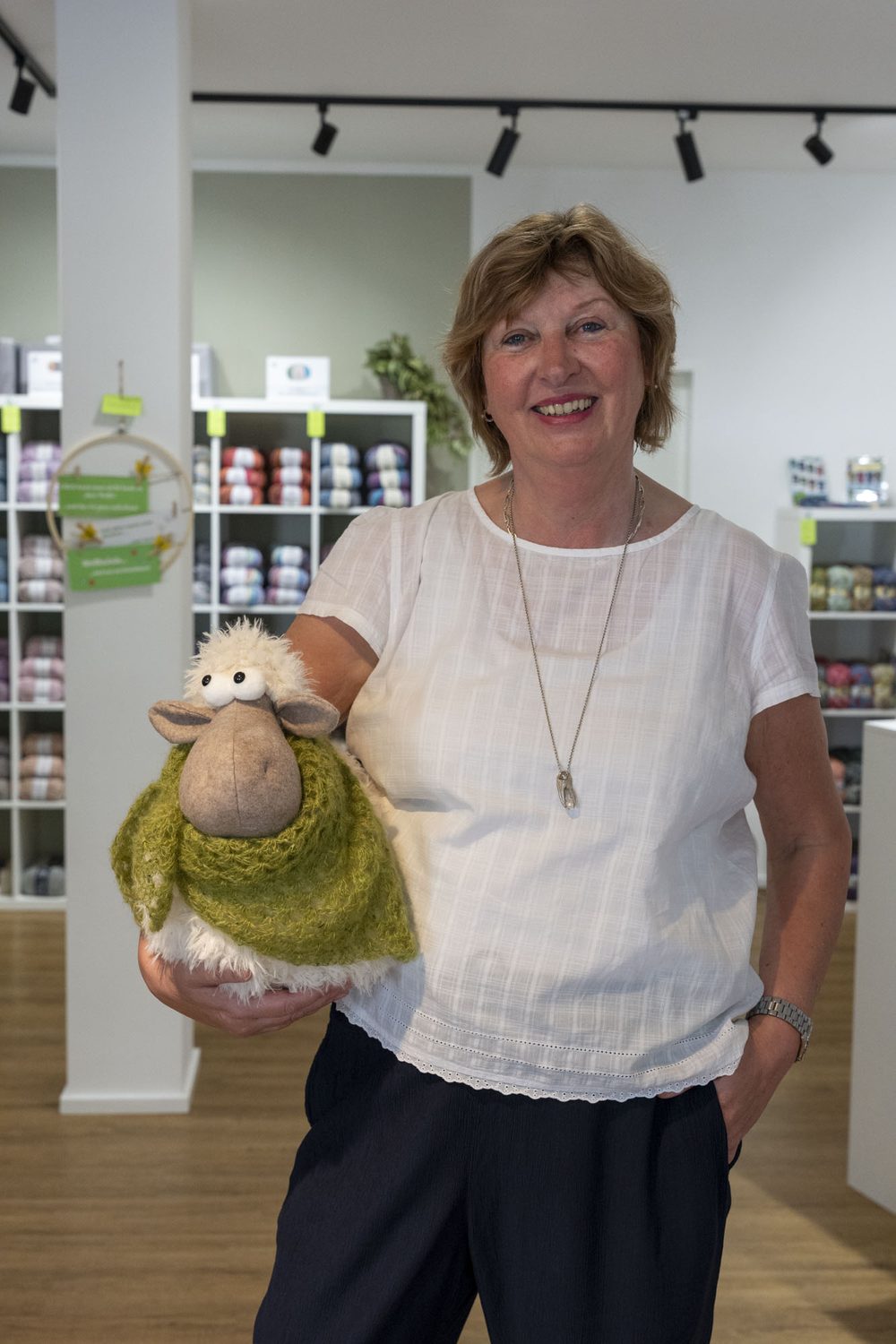 Inhaberin des Maschenwerk mit Schaf-Maskottchen
